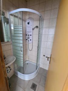um chuveiro com uma porta de vidro na casa de banho em Apartments and Rooms Ski em Vlasic
