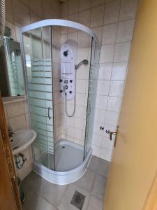 a shower with a glass door in a bathroom at Apartments and Rooms Ski in Vlasic +61 photos