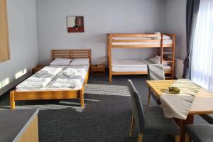 a room with two beds and a table and chairs at Apartments and Rooms Ski in Vlasic