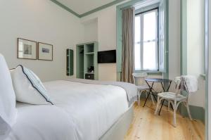 una camera con letto bianco, tavolo e finestra di Westlight Cascais Chalet - Adults Only a Cascais