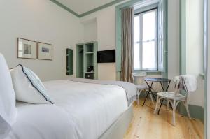 1 dormitorio con cama blanca, mesa y ventana en Westlight Cascais Chalet - Adults Only, en Cascais