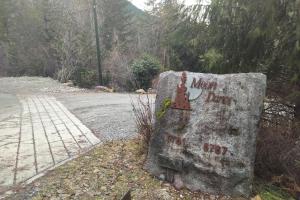 um sinal numa rocha ao lado de uma estrada em Moon Dance Perch em Madeira Park