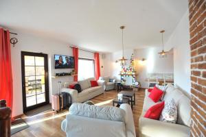 a living room with white furniture and a brick wall at VILA GIGI, ideala pentru relaxare si distractie! in Breaza