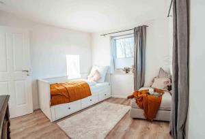 a white bedroom with a bed and a window at Knickblick in Brebel