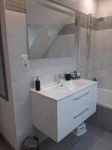 a white bathroom with a sink and a mirror at Maison TY PRAD bord de mer in Sarzeau