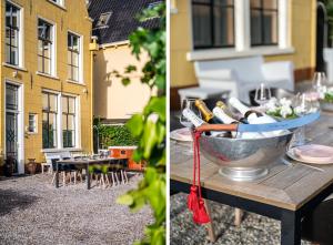 een tafel met een kom wijnflessen en een tafel met een gebouw bij De Olde Signorie in Leeuwarden