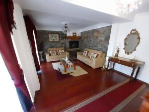 ein Wohnzimmer mit einem Sofa und einem Kamin in der Unterkunft Quintinha da Romana in Câmara de Lobos