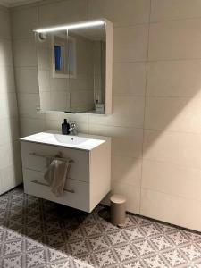 a bathroom with a white sink and a mirror at Lofoten - New apartment, close to airport. in Leknes
