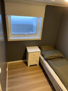 a small bedroom with a bed and a window at Lofoten - New apartment, close to airport. in Leknes