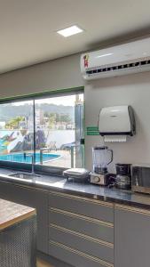 Innbox - Canasvieiras في فلوريانوبوليس: مطبخ مع كونتر توب مطل على المسبح