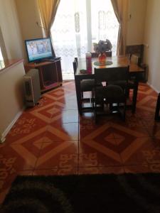 uma sala de estar com uma mesa de jantar e uma televisão em Departamento, Playa Bellavista, Tomé em Tomé