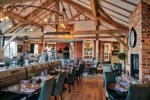 a dining room with tables and chairs and a clock at Hare and Hounds - Newbury in Newbury