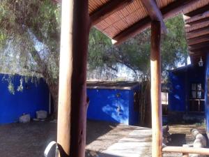 una casa azul con una pared azul y un árbol en Piedra Campana alojamiento en Tilcara