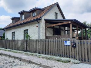 une maison avec une clôture en bois devant elle dans l'établissement Podzamcze15, à Kazimierz Dolny