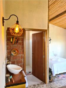 a bedroom with a bed and a sink and a light at Rancho da Montanha Cipó in Santana do Riacho
