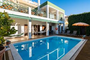 a villa with a swimming pool in front of a house at Holiday villa in elite residential area of Faro in Faro