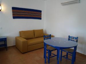 uma sala de estar com um sofá e uma mesa e cadeiras azuis em Casas da Minh'Alma em Reguengos de Monsaraz