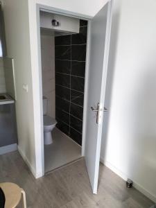 ein Bad mit einem WC und einer weißen Tür in der Unterkunft Appartement 2 pièces in Rive-de-Gier