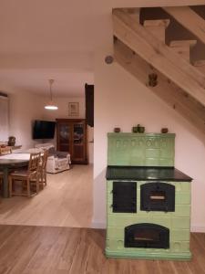 a green oven in a living room with a dining room at Podzamcze15 in Kazimierz Dolny