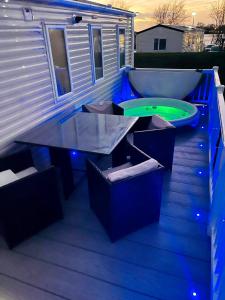 a deck with a tub and a table and a boat at The Sunflower Luxury caravan at Tattersall lakes in Tattershall
