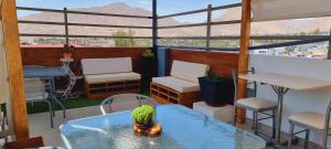 un patio con tavolo e sedie sul balcone. di Hostal Montalvo a Moquegua