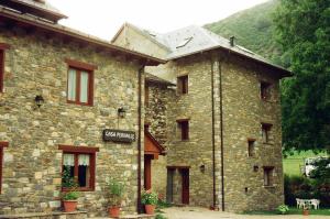 ein Steingebäude mit einem Schild an der Seite in der Unterkunft Hostal Pernalle in Erill la Vall