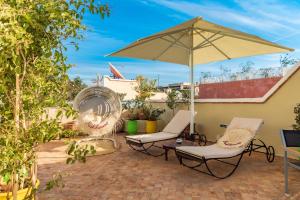 a patio with two chairs and an umbrella at Riad Luciano Hotel and Spa in Marrakech