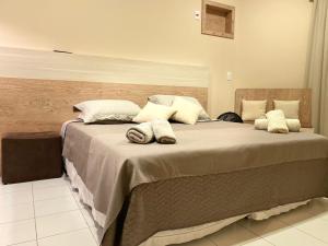 a large bed with pillows on it in a room at Studio em Caxambu in Caxambu