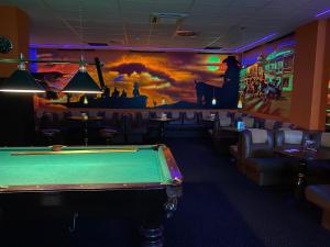 einen Billardtisch in einer Bar mit Wandgemälde in der Unterkunft Hotel Venus in Kolbudy