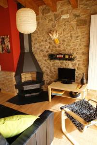 a living room with a brick wall with a stove at El Mas Prat in Vall de Bianya