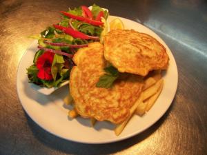 um prato branco com uma omelete e uma salada em Karamea Village Hotel em Karamea