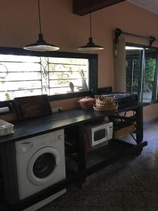 cocina con lavadora y mesa con microondas en La Esperanza en San Andrés de Giles