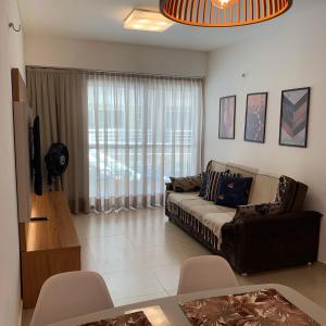 a living room with a couch and a large window at Beach Place - Apartamento 03 decorado a 100m da Praia do Cumbuco in Cumbuco