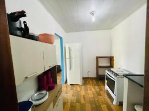 cocina con nevera blanca y suelo de madera en Pousada Aquarela, en Caraíva 44 fotos más