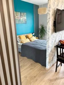 sypialnia z łóżkiem i niebieską ścianą w obiekcie Apartament Urodzajna w Bielsku Białej