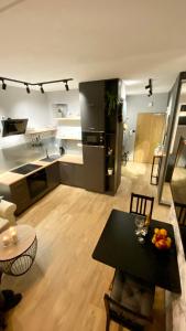 a kitchen with a table and a black refrigerator at Apartament Urodzajna in Bielsko-Biała