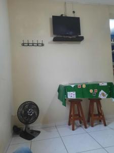 a room with a table and two stools and a television at Kit Ocian in Praia Grande