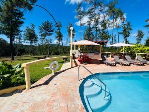 a pool with chairs and a gazebo at Kane Villas - Mountain Pine Ridge in San Ignacio