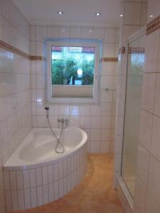 a bathroom with a bath tub and a window at Ferienwohnung Bergpanorama in Fulpmes