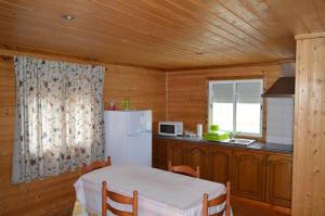 eine Küche mit einem Tisch und einem weißen Kühlschrank in der Unterkunft Quinta da Fonte de Grandola in Grândola