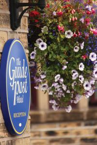 ein Schild an der Seite eines Gebäudes mit Blumen in der Unterkunft Best Western Bradford Guide Post Hotel in Bradford