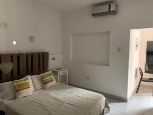 um quarto com uma cama num quarto branco em Departamentos Temporales Alberdi em La Rioja