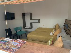 1 dormitorio con 2 camas y una cruz en la pared en Departamentos Temporales Alberdi en La Rioja