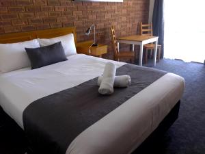 a bed with a stuffed animal sitting on top of it at Kerang Motel in Kerang