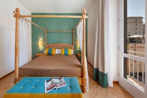 1 dormitorio con cama con dosel y ventana en Gorgeous apartment in the center: SORRENTO!, en Sorrento