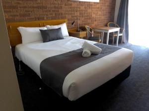 ein großes Bett in einem Hotelzimmer in der Unterkunft Kerang Motel in Kerang