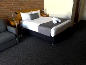 a hotel room with a bed and a chair at Kerang Motel in Kerang
