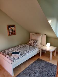 um pequeno quarto com uma cama e uma mesa em The Lovely Garden House em Zagreb