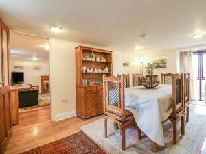 a dining room with a table and a kitchen at Barley Meadow in Bridestowe