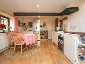 a kitchen with a table and chairs in it at Barley Meadow in Bridestowe